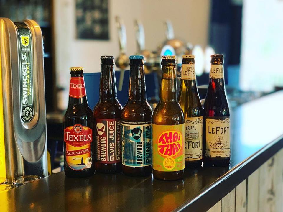 Verschillende flesjes bier met staan op de bar in Grotel's Genieten.